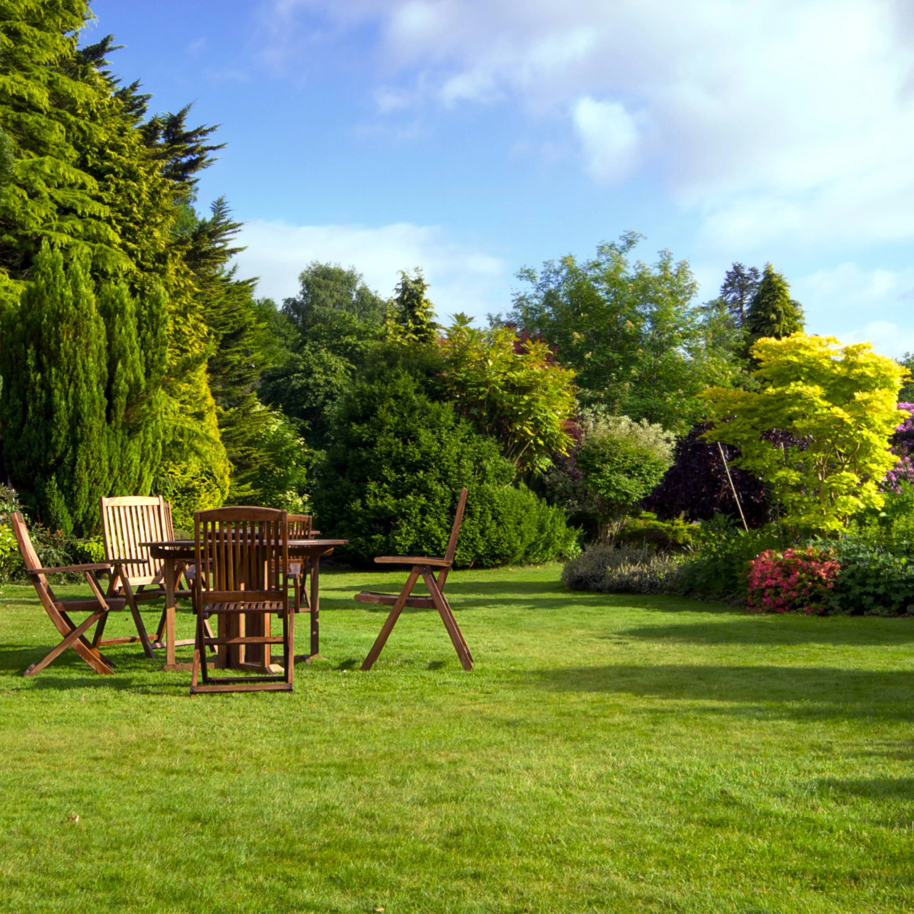 UK lawn with a wooden table and chairs in view