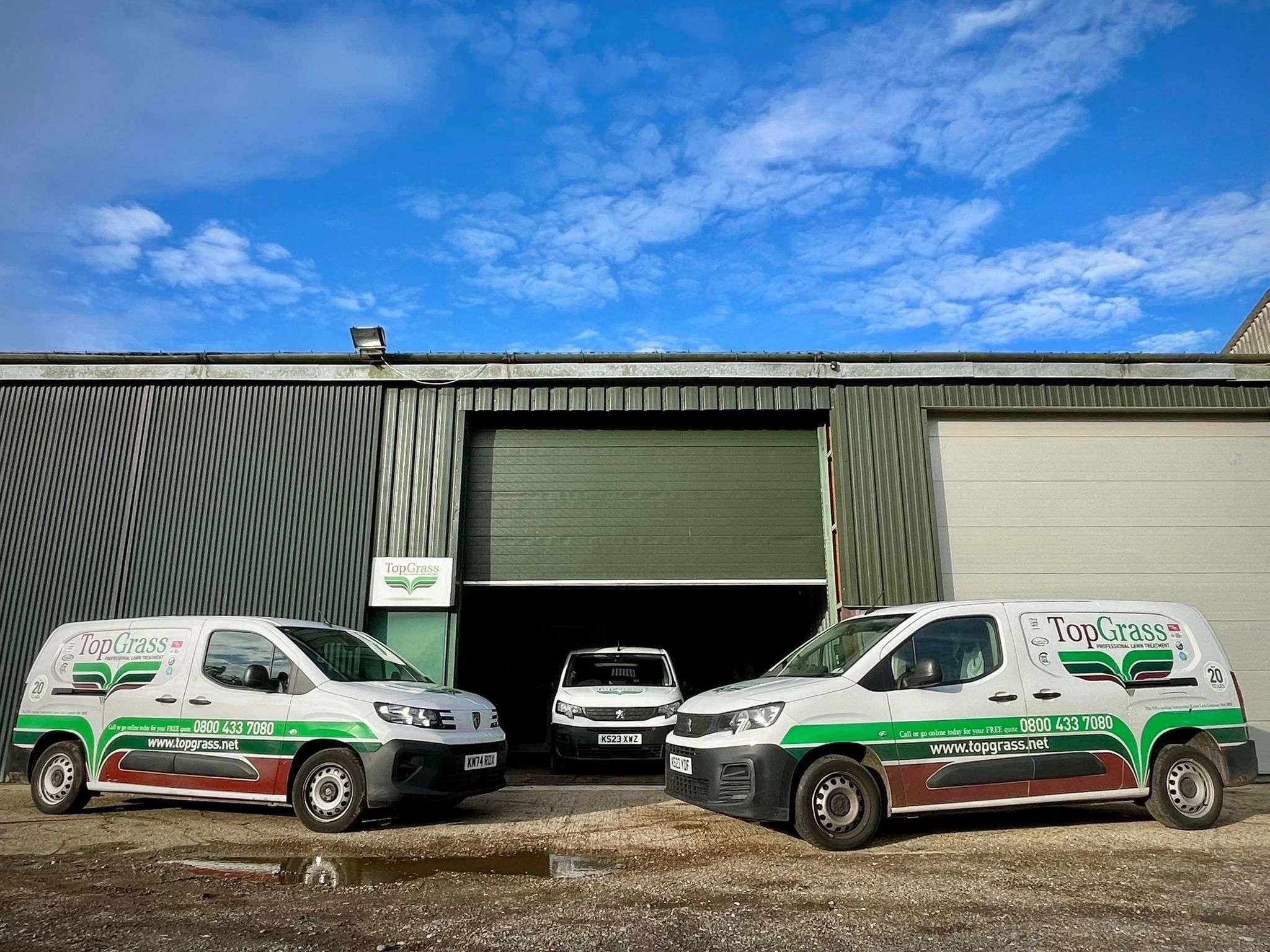 Image of depot with topgrass branded vans parked outside